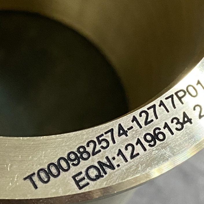 Referencias grabadas con láser en pieza mecánica en forma cilíndrica de anillo