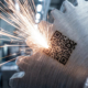 Grabado láser de un código QR en una pieza metálica industrial, imagen de portada para el artículo sobre trazabilidad en el sector industrial de CUSTOM3D.